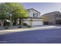 Two-story house with a beige exterior, a three-car garage, and nicely landscaped front yard at 1757 E Wildflower Ln, Casa Grande, AZ 85122