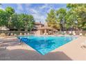 Community pool with ample lounge chairs and a covered patio area at 15225 N 100Th St # 2215, Scottsdale, AZ 85260