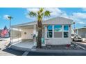 Front view of a manufactured home with carport, landscaping, and American flag at 420 Ironstone Dr, Apache Junction, AZ 85119