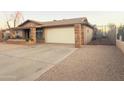 Ranch style home with a two-car garage and gravel driveway at 6943 W Virginia Ave, Phoenix, AZ 85035