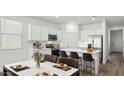 Modern kitchen with white cabinets, island, and stainless steel appliances at 25383 W Sunland Ave, Buckeye, AZ 85326