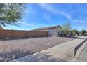 Single-story home with a gravel front yard and a brown block wall at 1619 E Joelle Dr, Casa Grande, AZ 85122