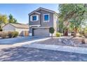 Gray two-story house with attached garage and landscaping at 17611 W Calavar Rd, Surprise, AZ 85388