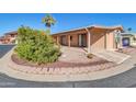 Tan mobile home with covered porch and manicured landscaping at 5735 E Mcdowell Rd # 270, Mesa, AZ 85215