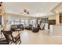 Spacious living room with leather furniture, a fireplace, and large windows at 27046 W Yukon Dr, Buckeye, AZ 85396