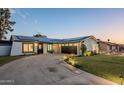 Modern home with a large driveway, solar panels, and well-manicured lawn at 3743 W Dailey St, Phoenix, AZ 85053