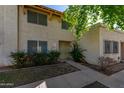 Tan stucco condo building with a walkway, landscaping, and trees at 8106 N 31St Dr, Phoenix, AZ 85051