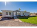 Gray house with a white door, paved walkway, and a lush green lawn at 249 N 89Th St, Mesa, AZ 85207