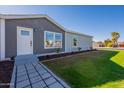 Modern home with gray siding, white door, and neatly landscaped front yard at 249 N 89Th St, Mesa, AZ 85207