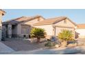 Tan two-car garage home with tile roof and mature landscaping at 664 W Jardin Dr, Casa Grande, AZ 85122