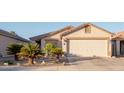 House exterior featuring a two-car garage and desert landscaping at 664 W Jardin Dr, Casa Grande, AZ 85122