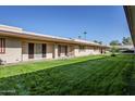 Wider view of the condo building, showing a large grassy yard at 12846 N 113Th Ave # 4, Youngtown, AZ 85363