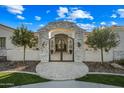 Stone archway and iron gate create an elegant entry to the home at 2335 E Plum St, Gilbert, AZ 85298
