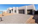 Modern home exterior with two-car garage and paved driveway at 34099 N Borgata Trl, Queen Creek, AZ 85144