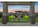 Covered patio with seating area overlooking a putting green at 16977 W Red Bird Rd, Surprise, AZ 85387