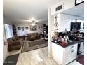 View of kitchen and living room with white cabinets and tile flooring at 9616 W Mountain View Rd # A, Peoria, AZ 85345