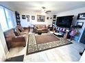 Spacious living room featuring two sofas, a large TV, and decorative rug at 9616 W Mountain View Rd # A, Peoria, AZ 85345