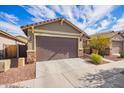 Single-story home with brown garage door and landscaping at 13315 N 143Rd Dr, Surprise, AZ 85379