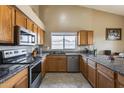 Kitchen with wood cabinets, granite countertops, and stainless steel appliances at 15547 W Magnolia St, Goodyear, AZ 85338