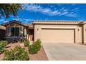 Tan house with two-car garage and desert landscaping at 20521 N Lemon Drop Dr, Maricopa, AZ 85138