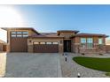 Two-story home with three-car garage, stone accents, and lush landscaping at 27712 N Hibiscus Ln, San Tan Valley, AZ 85143