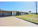 View of the home's side, showing carport and yard at 10307 W Oakmont Dr, Sun City, AZ 85351