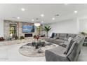 Spacious living room featuring a grey sectional sofa and fireplace at 1101 N Christa Way, Tolleson, AZ 85353