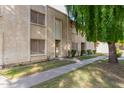 Tan two-story condo building with a walkway and landscaping at 8027 N 32Nd Ave, Phoenix, AZ 85051