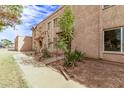 Side view of a light brown stucco condo building with walkways and landscaping at 8428 N 33Rd Dr, Phoenix, AZ 85051