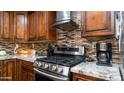 Modern kitchen features granite countertops, stainless steel gas cooktop and range hood at 1011 W Northern Ave, Phoenix, AZ 85021