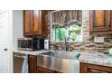 Kitchen with farmhouse sink, granite countertops, and dark wood cabinets at 1011 W Northern Ave, Phoenix, AZ 85021