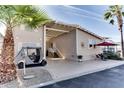 Tan home exterior with covered patio, golf cart, and palm trees at 17200 W Bell Rd # 1218, Surprise, AZ 85374