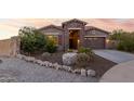 Stunning curb appeal with stone accents and a welcoming front porch at 18668 W Chuckwalla Canyon Rd, Goodyear, AZ 85338