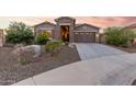 Beautiful home exterior featuring a stone facade and a spacious driveway at 18668 W Chuckwalla Canyon Rd, Goodyear, AZ 85338