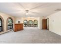 Bright living room with a wet bar, large windows, and a ceiling fan at 2716 E Voltaire Ave, Phoenix, AZ 85032