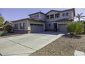 Two-story house with gray siding, a three-car garage, and a large driveway at 297 W Seaside Dr, Casa Grande, AZ 85122