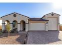 Tan two-story house with a three-car garage and desert landscaping at 5203 W Roundhouse Rd, Laveen, AZ 85339