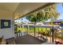 Covered porch with wrought iron gate and neighborhood view at 10213 W Kingswood Cir, Sun City, AZ 85351