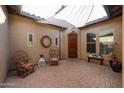 Inviting courtyard entry with sitting area and a wood door at 25995 N 85Th Dr, Peoria, AZ 85383