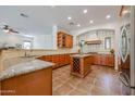 Island kitchen with granite countertops and wood cabinets at 25995 N 85Th Dr, Peoria, AZ 85383