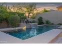 Inviting pool area with a waterfall feature and lush landscaping at 25995 N 85Th Dr, Peoria, AZ 85383