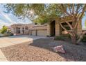 Two-story house with three-car garage, tree, and rock landscaping at 25714 N 70Th Ln, Peoria, AZ 85383