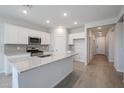 Modern kitchen with white cabinets, granite countertops, and stainless steel appliances at 39995 W Bravo Dr, Maricopa, AZ 85138