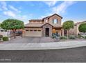 Two-story house with stone accents and a three-car garage, daytime view at 32388 N 129Th Dr, Peoria, AZ 85383