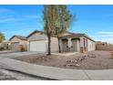 Attractive single-story home featuring a beige exterior, two-car garage, and landscaping at 9273 W Sheridan St, Phoenix, AZ 85037