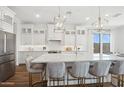 Modern white kitchen with large island and stainless steel appliances at 698 E Aurora Dr, San Tan Valley, AZ 85140