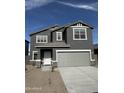 Two-story home with gray siding, two-car garage, and front yard landscaping at 2084 E Grazing Meadow Ln, San Tan Valley, AZ 85140