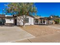 Front view of a charming house with a carport and large tree at 1818 E Monterey Way, Phoenix, AZ 85016