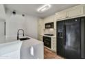 Modern kitchen with white cabinets, quartz countertops, and black appliances at 4808 N 24Th St # 531, Phoenix, AZ 85016