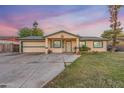 Single story home with attached garage and grassy yard at 6415 W Roosevelt St, Phoenix, AZ 85043